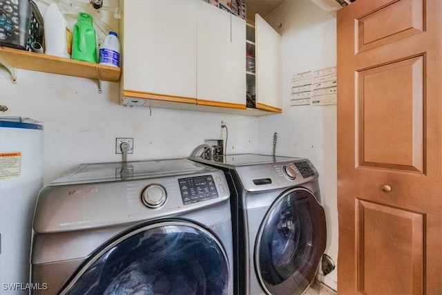 washroom featuring water heater, cabinets, and washing machine and clothes dryer