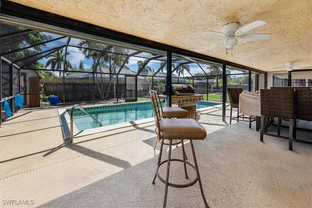 view of swimming pool featuring ceiling fan, a lanai, and a patio