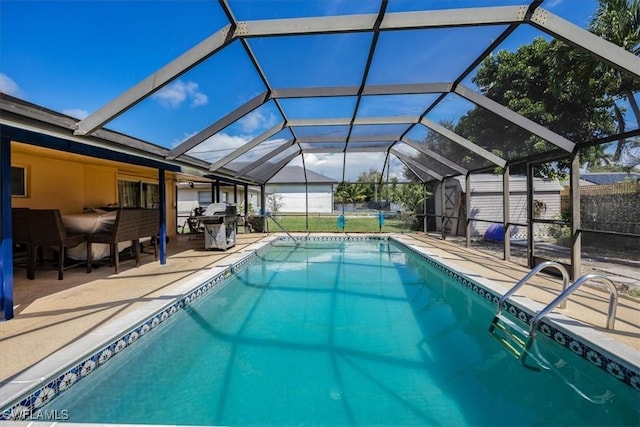 view of pool with a lanai, a patio, and a shed