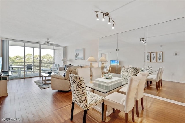 dining space featuring ceiling fan, baseboards, wood finished floors, and floor to ceiling windows