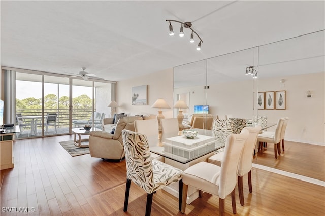 dining space with ceiling fan, hardwood / wood-style floors, and expansive windows