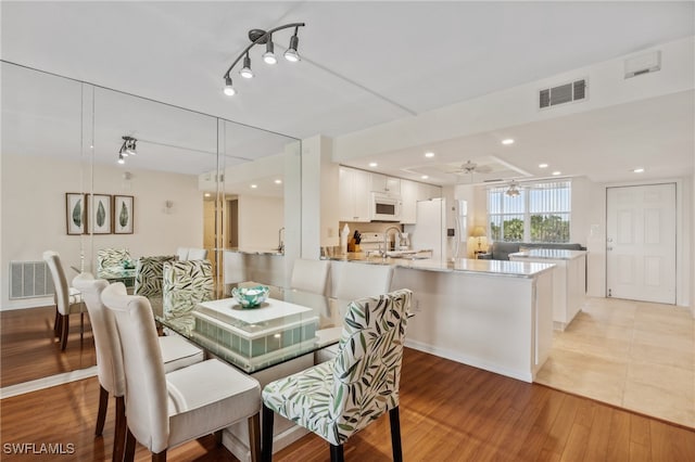 dining room featuring ceiling fan, light hardwood / wood-style flooring, and sink