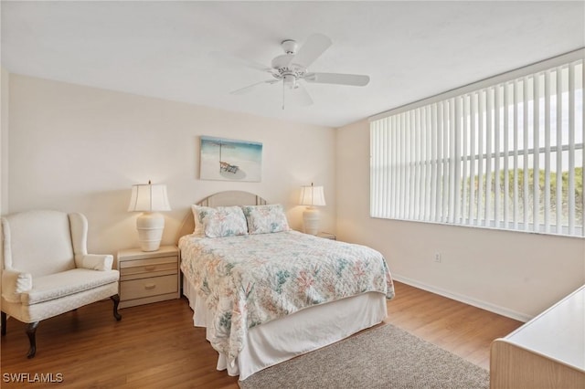 bedroom featuring a ceiling fan, baseboards, and wood finished floors