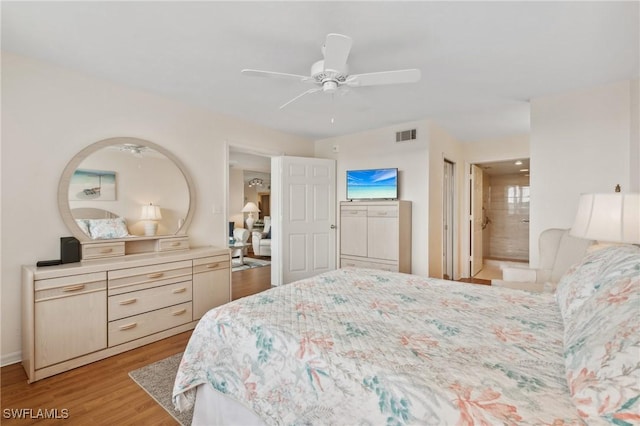 bedroom featuring a ceiling fan, visible vents, light wood-type flooring, and connected bathroom