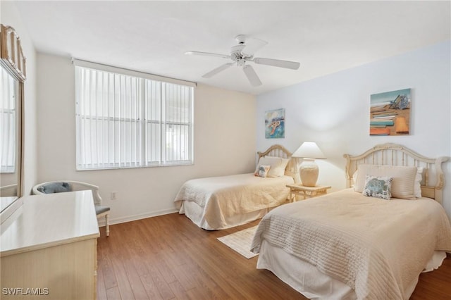 bedroom featuring wood finished floors, baseboards, and ceiling fan