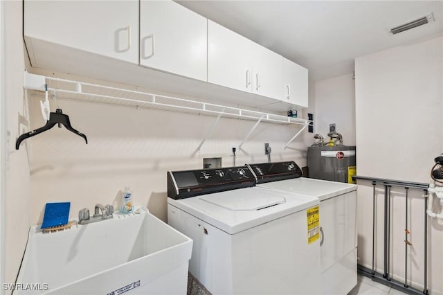 clothes washing area featuring visible vents, cabinet space, separate washer and dryer, a sink, and electric water heater