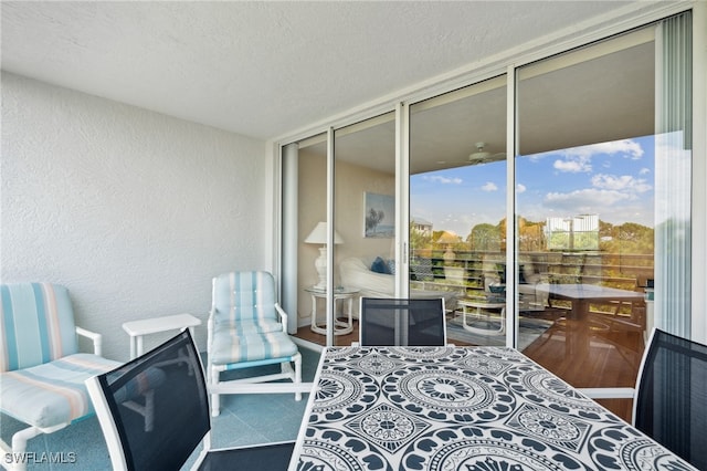 bedroom with a textured ceiling, access to outside, and expansive windows