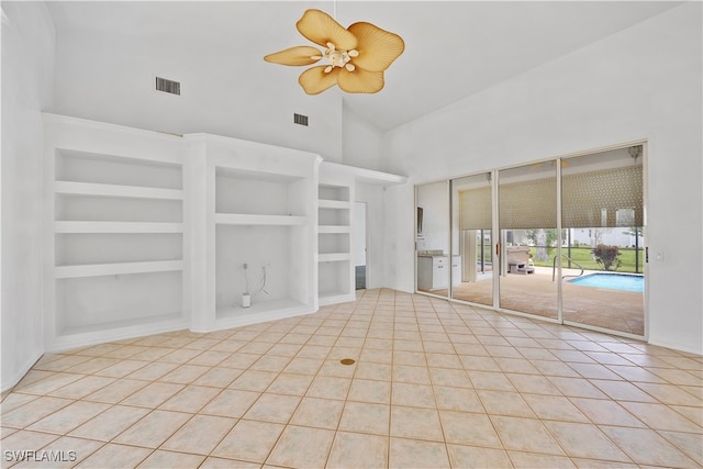 unfurnished room featuring light tile patterned floors, ceiling fan, built in features, and high vaulted ceiling