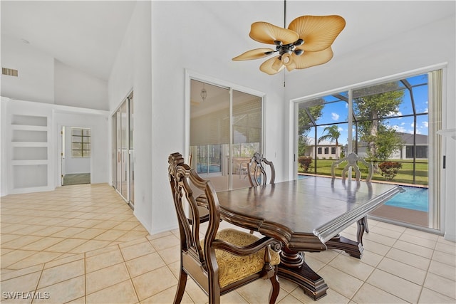 dining space with light tile patterned floors, ceiling fan, and high vaulted ceiling