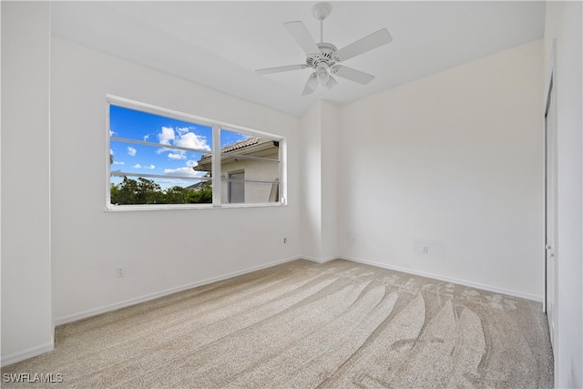 carpeted spare room with ceiling fan