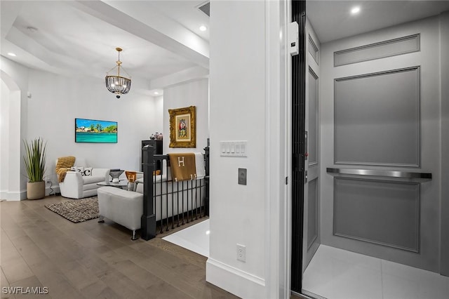 hall featuring hardwood / wood-style floors and a chandelier