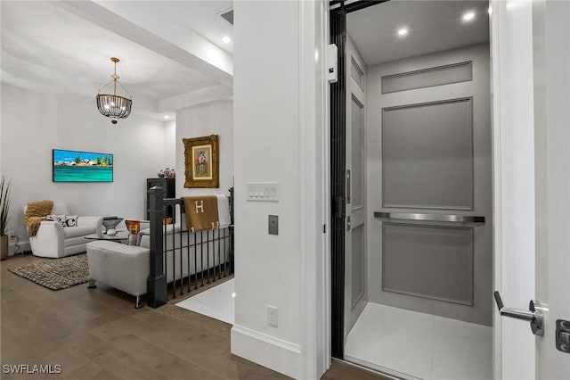 hall featuring an inviting chandelier and wood-type flooring