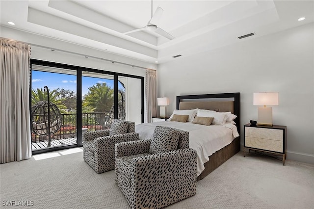 bedroom featuring ceiling fan, a raised ceiling, light colored carpet, and access to outside