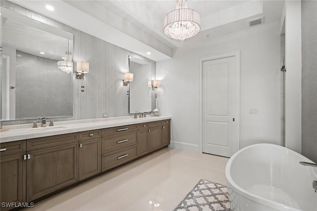 bathroom featuring a bath, vanity, an inviting chandelier, and tile patterned floors