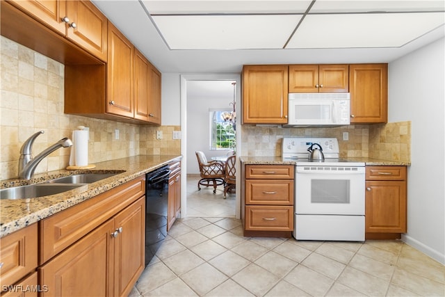 kitchen featuring decorative backsplash, white appliances, light stone countertops, light tile patterned floors, and sink