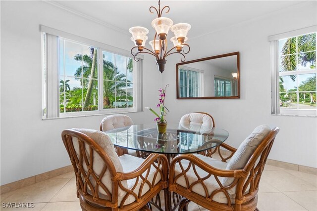 dining room with a notable chandelier, crown molding, and light tile patterned floors