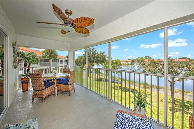 sunroom / solarium with a water view and ceiling fan