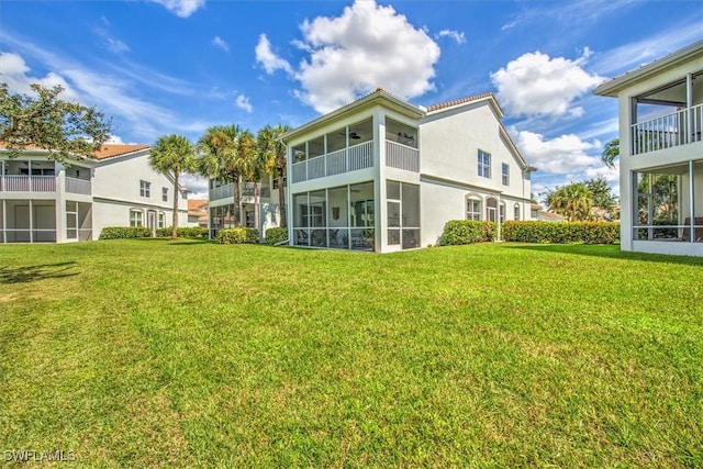 rear view of house with a yard and a sunroom