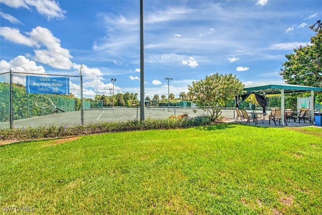 view of sport court featuring a lawn and fence