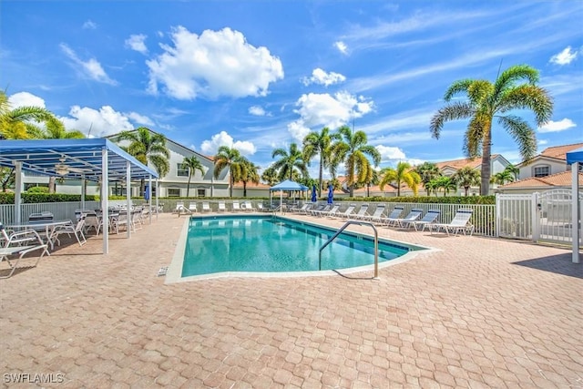 community pool with a patio and fence