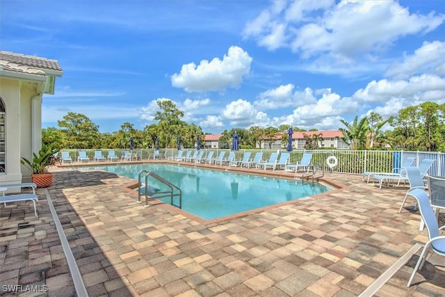 community pool featuring a patio area and fence