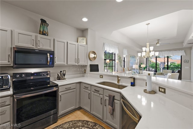 kitchen featuring a healthy amount of sunlight, stainless steel appliances, decorative light fixtures, and a notable chandelier