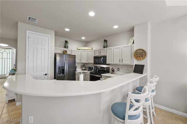 kitchen featuring kitchen peninsula, white cabinets, black appliances, and light tile patterned floors