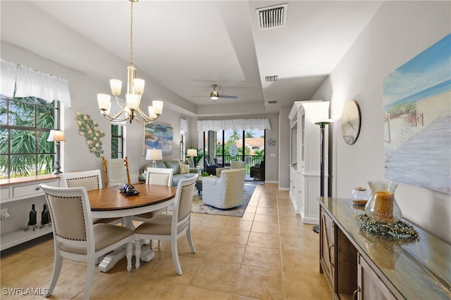 dining area featuring ceiling fan with notable chandelier and light tile patterned flooring