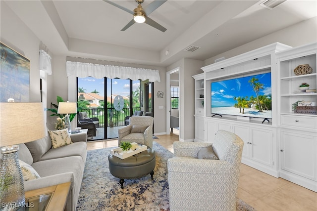 tiled living room featuring a tray ceiling and ceiling fan