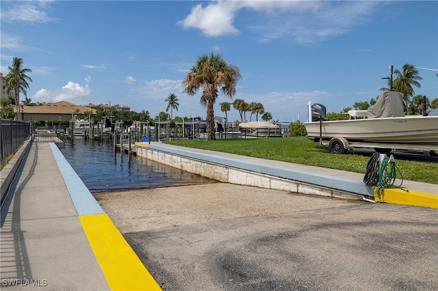 view of community featuring a boat dock, a water view, and a yard