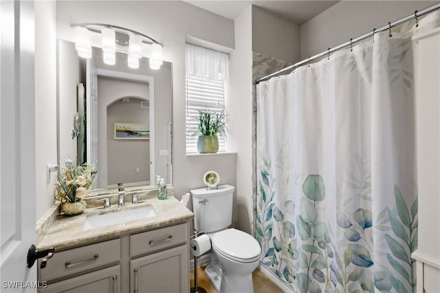 bathroom featuring vanity, toilet, and walk in shower