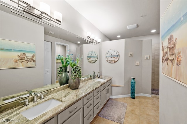 bathroom featuring tile patterned floors, vanity, and a tile shower