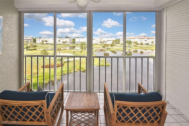 sunroom / solarium featuring a water view and ceiling fan