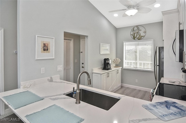 kitchen featuring ceiling fan, white cabinets, sink, kitchen peninsula, and appliances with stainless steel finishes