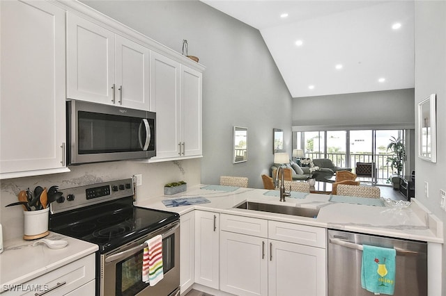 kitchen featuring appliances with stainless steel finishes, kitchen peninsula, sink, and white cabinets