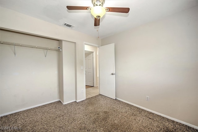 unfurnished bedroom with ceiling fan, light colored carpet, and a closet