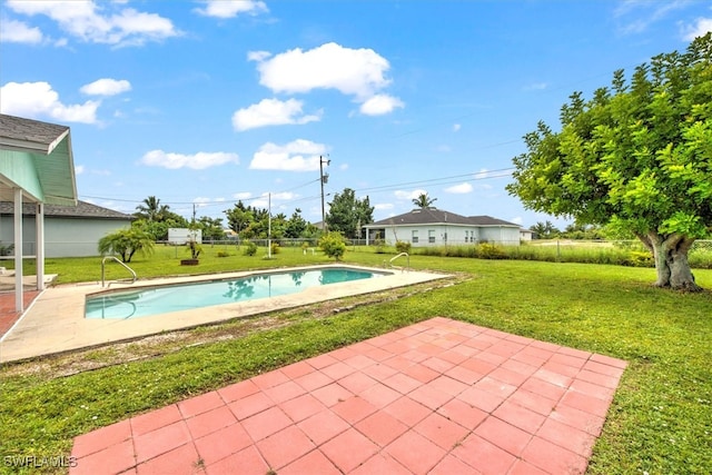 view of pool with a lawn and a patio area