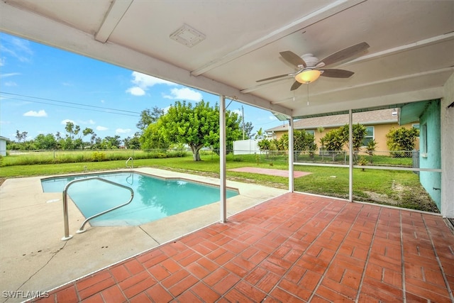 view of swimming pool with a lawn, ceiling fan, and a patio area