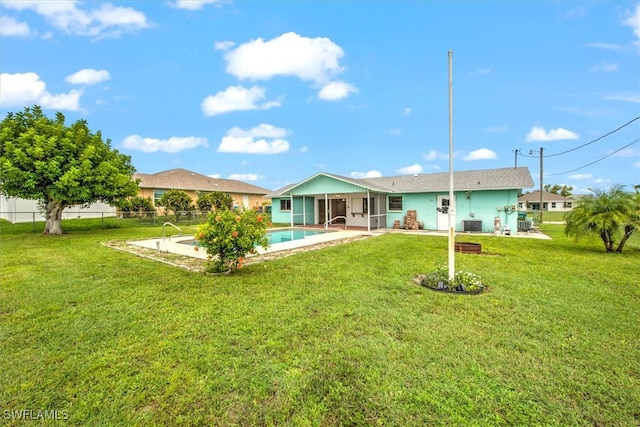 back of house featuring a fenced in pool, a yard, and a patio