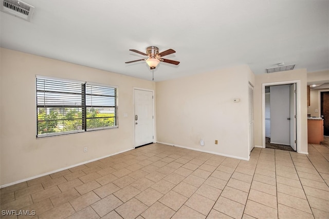 tiled spare room featuring ceiling fan