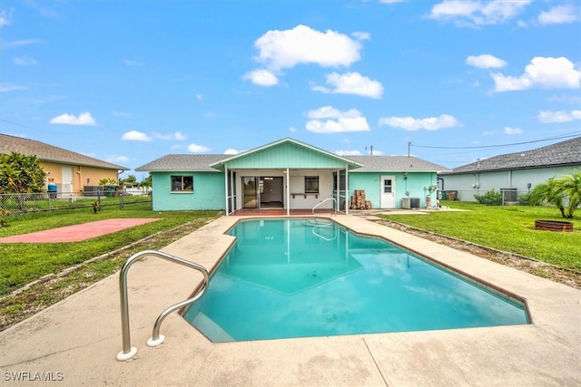 view of swimming pool featuring central AC unit, a yard, and a patio area