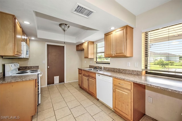 kitchen with white appliances, a tray ceiling, light tile patterned floors, and sink