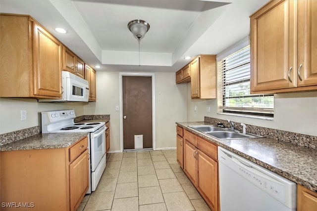 kitchen with light tile patterned floors, a tray ceiling, sink, and white appliances