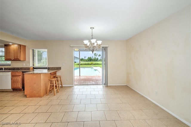 kitchen with dishwasher, a breakfast bar area, light tile patterned floors, an inviting chandelier, and decorative light fixtures