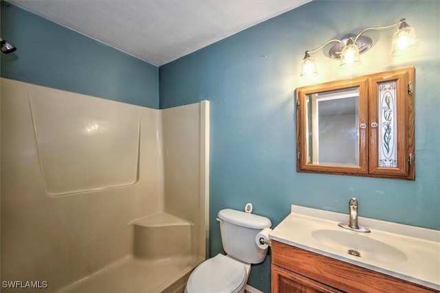 bathroom featuring vanity, a shower, and toilet