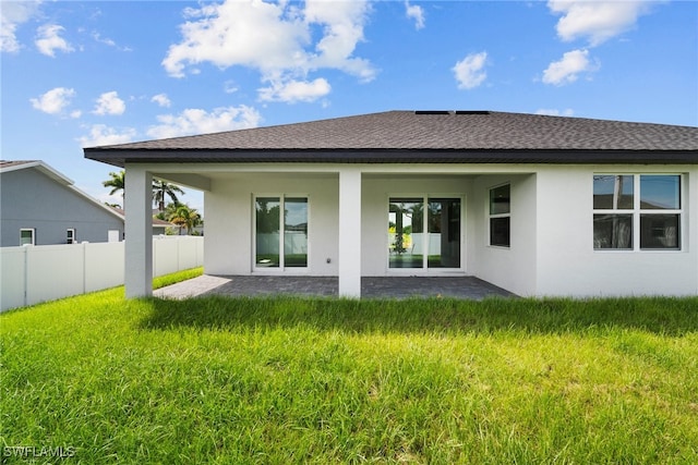 rear view of property with a yard and a patio