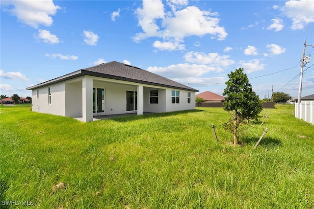 back of house featuring a lawn