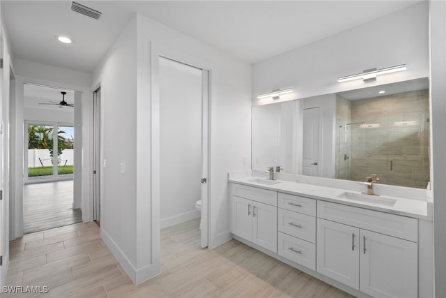 bathroom featuring vanity, ceiling fan, hardwood / wood-style flooring, toilet, and a shower with shower door