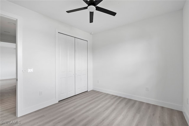 unfurnished bedroom with light wood-type flooring, a closet, and ceiling fan