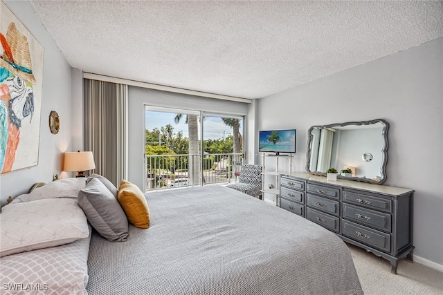 carpeted bedroom with a textured ceiling and access to exterior